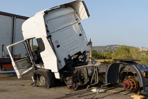 Damaged white truck involved in a severe accident, with significant front-end destruction