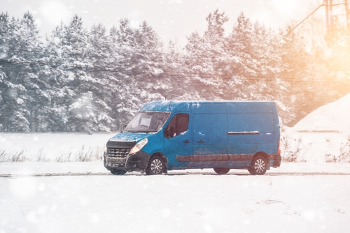 blue truck driving in the snow